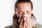 Girl with cold sneezing in handkerchief wearing scarf and sweater