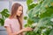 Girl collects cucumbers in the summer in a greenhouse