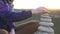 Girl collects a pyramid of stones close up at sunset,slow mo