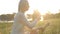 Girl collects wildflowers at sunset