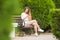 Girl communicates in social networks sitting on a park bench