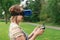 The girl controls a quadrocopter in the park with the help of a VR helmet. The concept of virtual reality. extra reality