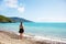 Girl on coral beach looking out to sea