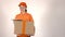 Girl courier in orange uniform delivering big cardboard parcel. 4K shot, isolated
