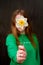 Girl covered her face with a daffodil flower,
