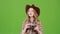 Girl in a cowboy hat walks and photographs beautiful buildings. Green screen