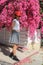 Girl in cowboy`s hat beside pink flowers