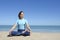 girl in cross-legged yoga lotus pose at beach