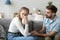 Girl crying sitting together with guy on couch at home