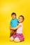 Girl cuddle standing child while sitting on floor