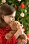 Girl Cuddling Teddy In Front Of Christmas Tree