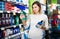 Girl customer looking for effective mouthwash in supermarket