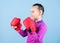 Girl cute boxer on blue background. Contrary to stereotype. Boxer child in boxing gloves. Confident teen. Enjoyment from
