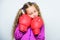 Girl cute child with red gloves posing on white background. Sport upbringing. Upbringing for leader. Strong child boxing