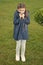 Girl cute face braided hair posing coat in spring park. Clothing for spring walks. Little fashion model. Clothes and