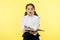 Girl cute schoolgirl in uniform hold book with information yellow background. Pupil get information from book. Child