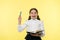 Girl cute schoolgirl in uniform hold book or textbook yellow background. Diligent pupil get knowledge from book. Child