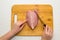 Girl cuts chicken fillet on a wooden Board. Women`s hands, wooden Board, knife. Top view