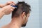 Girl cuts hair with a clipper on a manâ€™s head at home in the bathroom