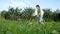 The girl cuts the thick grass with an electric lawn mower