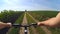 A girl cyclisted on a road through a green field