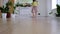 A girl dances with a mop to clean the floor in a new house - general cleaning in an empty room, the joy of moving, help with the