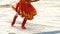 Girl dancing folk dance in red costume and red boots