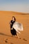 Girl dancing on the sand in the desert.