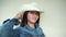 Girl with dark hair in denim jacket and in white cowboy hat