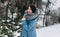 Girl with dark hair with natural silver fox fur posing in a snowy forest.