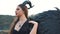 Girl in dark vintage dress with huge heavy strong wings behind her back removes her long hair from her face with gentle