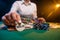 Girl dealer holding a dealer chip in a casino at the gaming table. Las Vega, gaming business. Concept of gaming business and