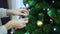 The girl decorates the Christmas tree, hangs a toy in the shape of the Icelandic bird Fratercula arctica on a branch.