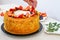 Girl decorates a freshly baked puff cake with fruits and berries: strawberries, blueberries and physalis Cooking and decorating a