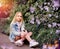 Girl in a denim jacket walks in a flowering garden