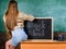 Girl denim skirt breaking school clothing rules. School dress code. Back and buttocks student near chalkboard. Student