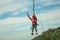 Girl descending by cables in a zip-line on forest