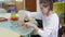 a girl with disabilities builds a tower of wooden cubes sitting at a table in a wheelchair.