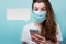 Girl in a disposable medical mask and hospital clothes holds a smartphone in her hand. Speech bubble