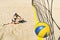 Girl with a dissatisfied face falls on sand hitting ball into net. Losing the championship in beach volleyball. Sports