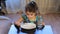 Girl distracted while eating. Little girl eats porridge. Looking away