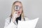 Girl doctor examines the patient\\\'s analyzes with a magnifying glass. She is shocked and upset by the bad news written in the