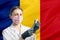 Girl doctor prepares vaccination against the background of the Romania flag. Vaccination concept Romania