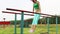 Girl does exercise on parallel bars at summer evening outdoor