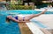 The girl does gymnastics in the outdoor pool