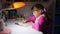 A girl does homework late in the evening under the light of a table lamp