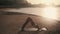Girl does revolved side angle and cobra yoga poses on beach