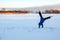 girl does sports in nature on winter morning. Teenage girl does handstand in snow. Concept of sports