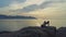 Girl does yoga exercises lying on rock against ocean