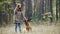 Girl With a Dog - german shepherd - at autumn forest - young pretty woman standing on meadow, petting her dog and laughs